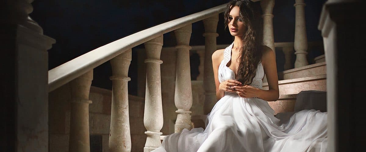beautiful woman sitting on steps in darkened room