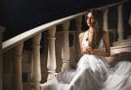 beautiful woman sitting on steps in darkened room